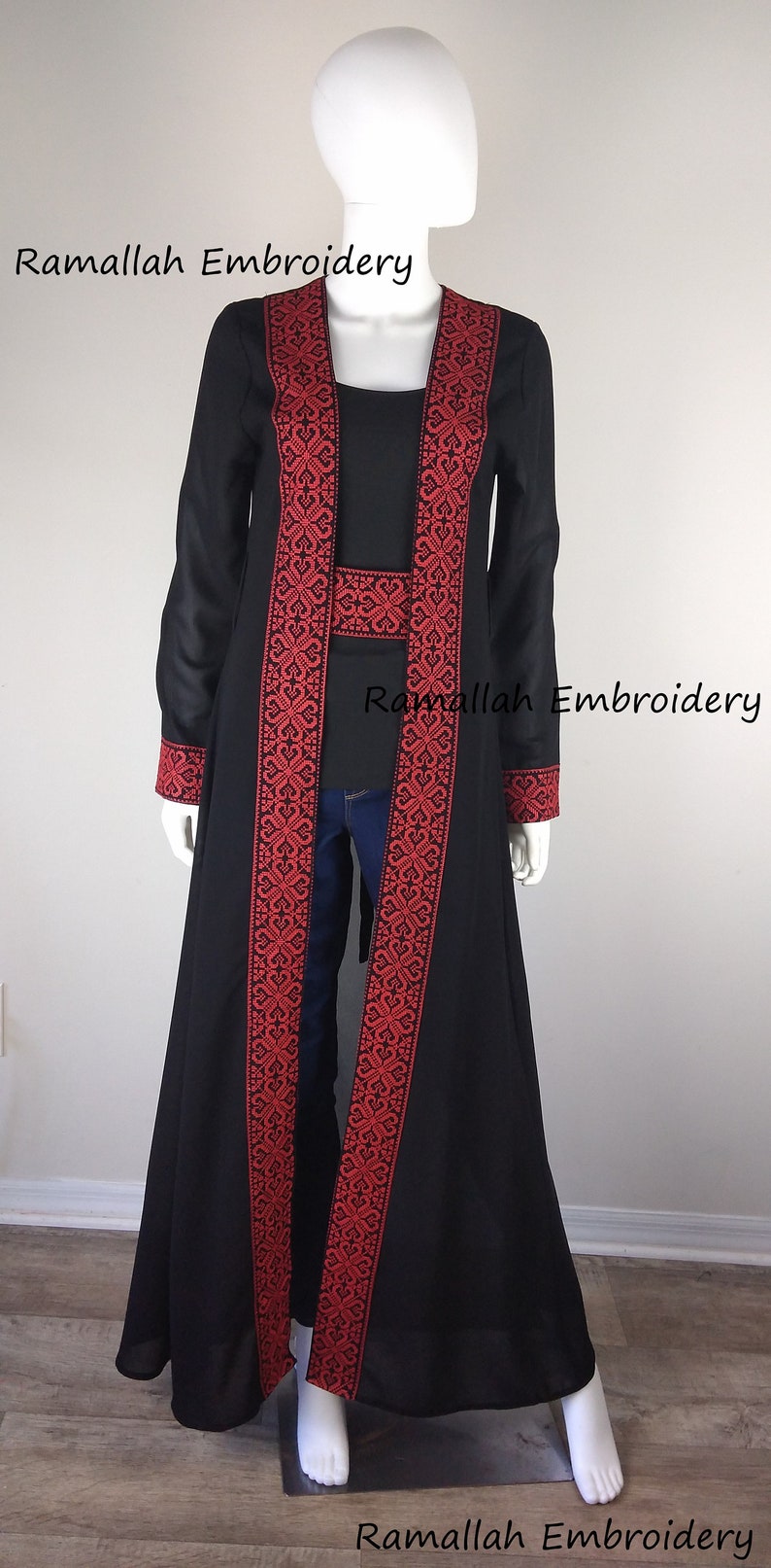Puede incluir: Una larga chaqueta negra con ribetes bordados en rojo. La chaqueta tiene una silueta larga y fluida y es perfecta para superponer sobre un vestido o pantalones.