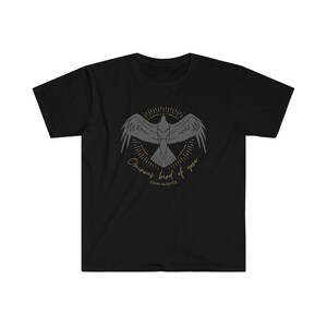 Puede incluir: Camiseta negra con un gr&aacute;fico de un cuervo en vuelo, rodeado de un c&iacute;rculo de rayos de sol. El texto "Once upon a midnight dreary" y "Edgar Allan Poe" est&aacute;n impresos debajo del cuervo.