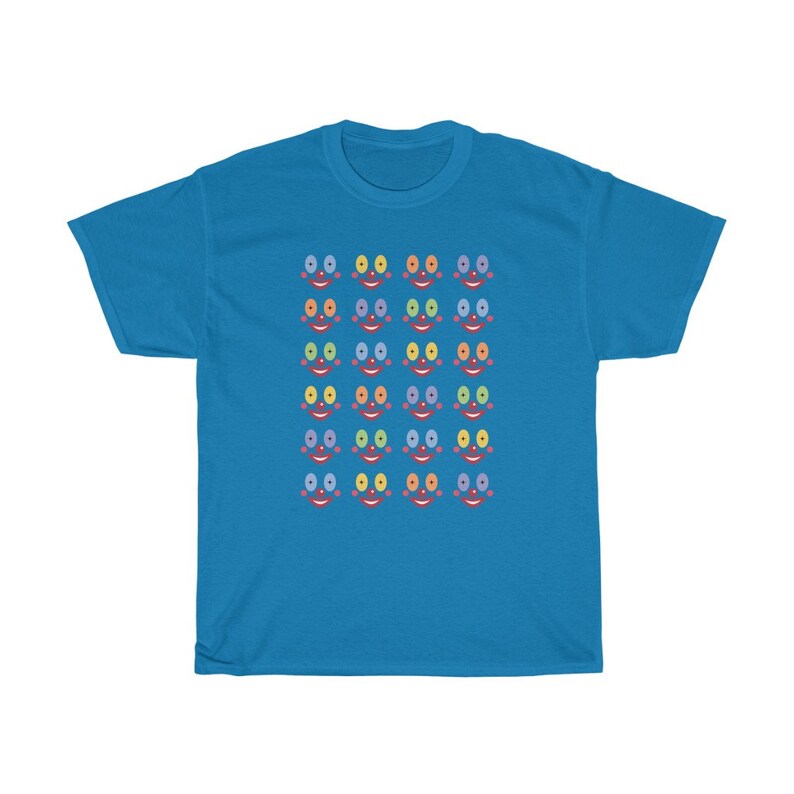 May include: A bright blue t-shirt with a pattern of colorful faces. Each face has a red mouth, two eyes, and a nose. The eyes are different colors, including blue, green, yellow, and orange.