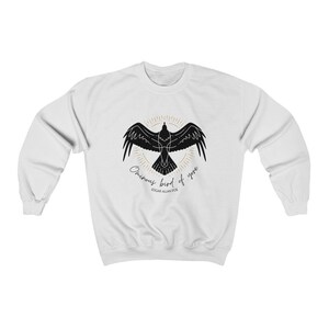 K&ouml;nnte beinhalten: Wei&szlig;er Pullover mit einer schwarzen Silhouette eines Rabens mit dem Text "Once upon a midnight dreary" und "Edgar Allan Poe" auf der Vorderseite.