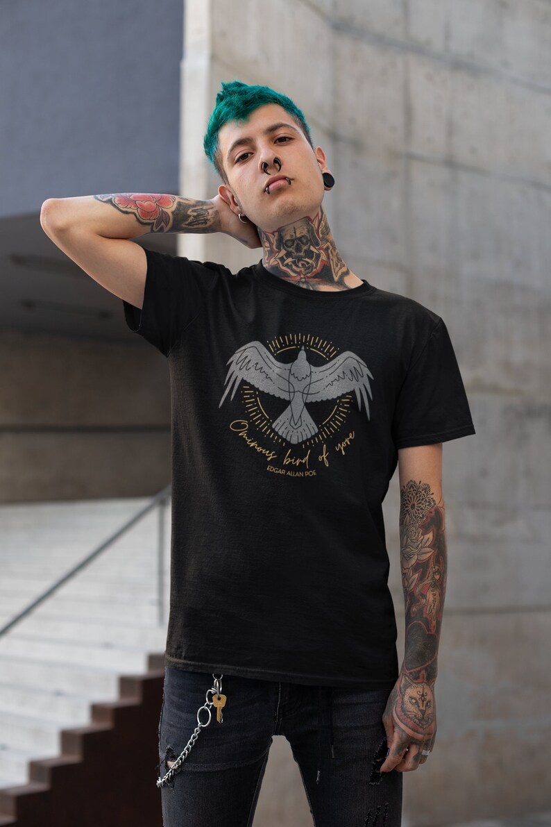 May include: A black t-shirt featuring a graphic of a bird in flight with the text "Ominous bird of yore" and "Edgar Allan Poe" underneath.