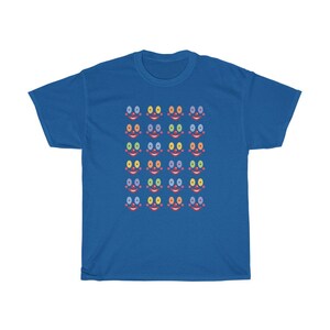 May include: A royal blue t-shirt with a pattern of colorful smiling faces. Each face has a red mouth, blue, yellow, or green eyes, and a pink nose.