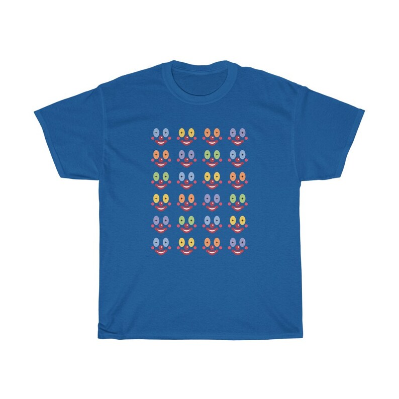 May include: A royal blue t-shirt with a pattern of colorful smiling faces. Each face has a red mouth, blue, yellow, or green eyes, and a pink nose.