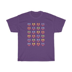 May include: Purple t-shirt with a pattern of colorful smiling faces. Each face has a different colored eye and mouth.
