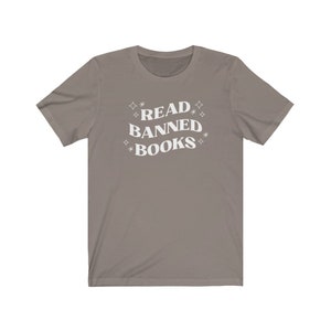 May include: A gray t-shirt with the text "READ BANNED BOOKS" in white lettering with stars around the text.