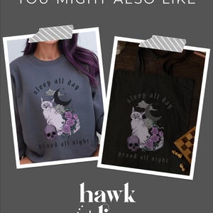 K&ouml;nnte beinhalten: Zwei Bilder einer schwarz-wei&szlig;en Katze mit einem Sch&auml;del und Blumen. Die Katze sitzt auf einem Halbmond. Der Text "sleep all day brood all night" ist auf beiden Bildern. Ein Bild ist ein Sweatshirt und das andere ist eine Tragetasche. Der Text "hawk + lion studio" befindet sich am unteren Rand des Bildes.