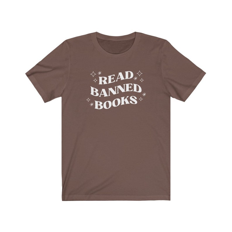 May include: A brown t-shirt with the text "READ BANNED BOOKS" in white lettering with stars around the text.