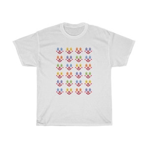May include: White t-shirt with a pattern of colorful clown faces. Each face has a red nose and rainbow colored eyes.