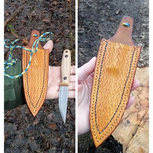 Könnte beinhalten: Ein handgefertigtes Leder-Messerscheide und Messer-Set. Die Scheide ist hellbraun mit einem gewebten Muster und blauen Nähten. Das Messer hat einen Holzgriff und eine silberne Klinge. Das Set wird im Freien gezeigt.