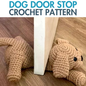 Op de afbeelding: Gehaakte deurstopper in de vorm van een hond, gemaakt van beige garen. De hond heeft een staart en een kop. De tekst "DOG DOOR STOP CROCHET PATTERN" staat bovenaan de afbeelding.
