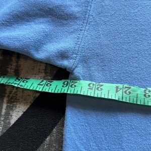 Peut inclure: Un gros plan sur un tissu bleu clair avec un ruban &agrave; mesurer indiquant 26 pouces.