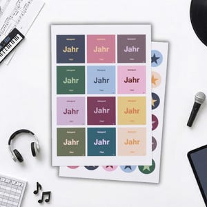 Könnte beinhalten: Eine Sammlung von Musikartikeln, darunter eine Miniaturgitarre, eine Tastatur, Kopfhörer, Noten und eine Schallplatte. Es gibt auch bunte Aufkleber und ein Tablet mit dem Text "MUSIK QUIZ". Ein Blatt Papier trägt das Wort "Jahr".