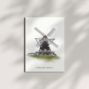 Könnte beinhalten: Eine Aquarell-Illustration einer traditionellen Windmühle mit einem schwarzen Holzsockel und weißen Flügeln. Die Windmühle steht vor einem weißen Hintergrund mit einem hellgrünen Grasbereich am Fuß. Der Text "Nordernauble Pellworm" steht unter der Windmühle.