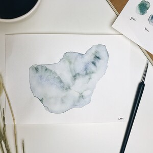 Könnte beinhalten: Ein Aquarellbild einer blauen und grünen abstrakten Form auf weißem Papier. Das Bild ist unten rechts mit "LMT" signiert.