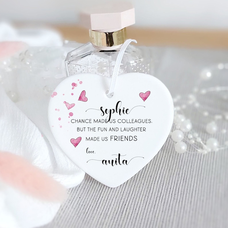 Puede incluir: Adorno de cer&aacute;mica blanco en forma de coraz&oacute;n con corazones rosas de acuarela y el texto "Sophie CHANCE MADE US COLLEAGUES. BUT THE FUN AND LAUGHTER MADE US FRIENDS love. anita"