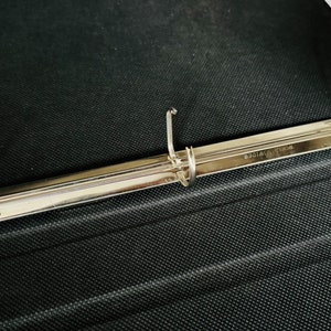 May include: A silver binder mechanism with three rings and the text "WORLD WIDE" engraved on the metal.