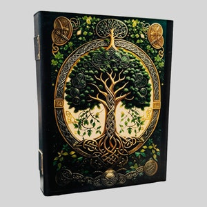 May include: A black leather journal with a gold Celtic knot design featuring a green tree of life. The journal has a decorative spine and a gold clasp.