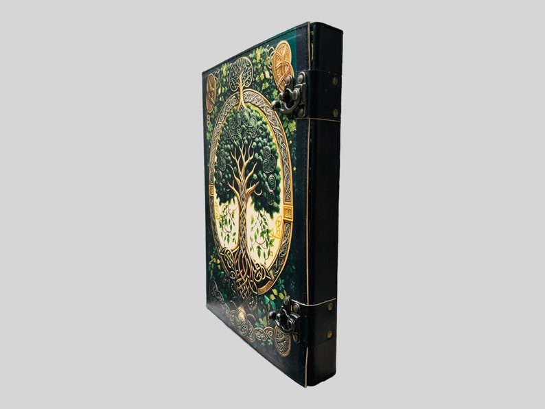 May include: A dark green leather-bound journal with a Celtic tree of life design. The cover features intricate gold details and a tree with green leaves. The journal has two metal clasps.