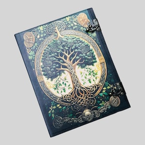 May include: A dark green leather journal with a gold Celtic knot design and a tree of life illustration. The journal has two metal clasps.