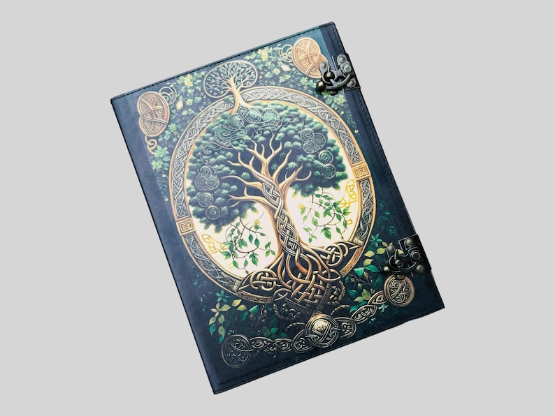 May include: A dark green leather journal with a gold Celtic knot design and a tree of life illustration. The journal has two metal clasps.