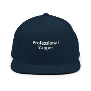 May include: A navy blue baseball cap with a white embroidered design that says "Professional Yapper".