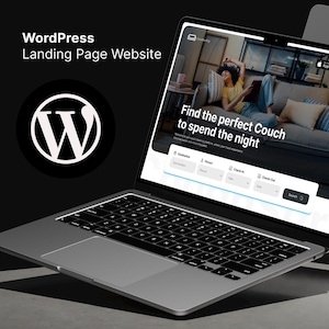 May include: A laptop computer displaying a website with the text "Find the perfect Couch to spend the night". The website has a search bar and fields for entering a destination, dates, and check-in and check-out times. The laptop is on a grey surface.