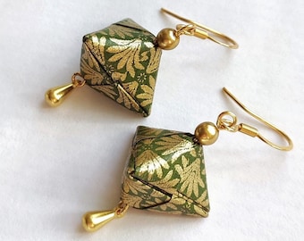 Könnte beinhalten: Ein Paar grüne und goldene Origami-Ohrringe in geometrischer Diamantform. Die Ohrringe haben einen goldenen Haken und einen kleinen goldenen Tropfen.