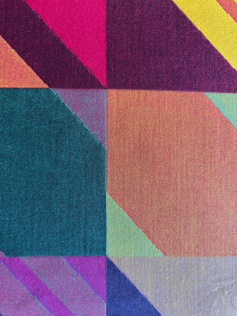 May include: Abstract textile pattern featuring geometric shapes in vibrant colors. The design includes squares and diagonal lines in shades of pink, purple, teal, orange, and yellow. The fabric has a textured appearance.