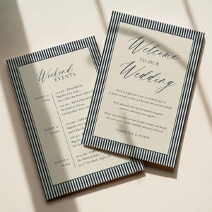 May include: Two rectangular wedding stationery cards with a cream background and a dark navy blue vertical striped border. The top card reads Welcome to our Wedding, and the bottom card lists Weekend Events with a schedule for August 15, 16, and 17.