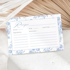 Pu&ograve; includere: Un biglietto di ricetta bianco con un bordo floreale blu e la parola "Recipe" in elegante scrittura. Il biglietto include spazi per "Serves", "Ingredients", "Prep", "Directions" e "Cook Time".