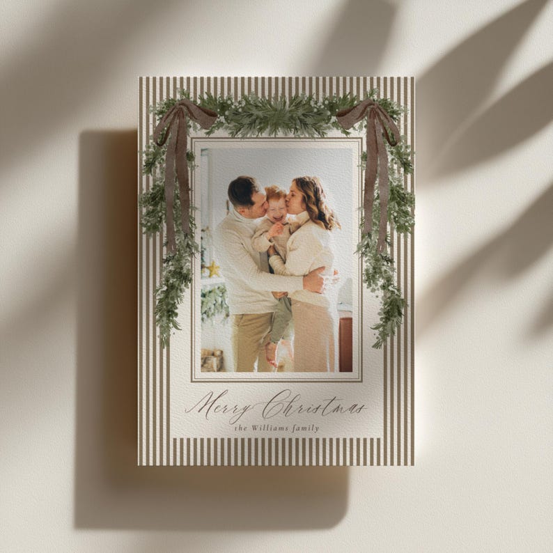 Classic greenery Christmas photo card template with neutral brown stripes and personalized family photos, perfect for an elegant and timeless holiday