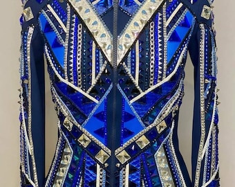 May include: A navy blue show jacket with a geometric design featuring blue, white, and silver accents. The jacket is embellished with rhinestones and studs.