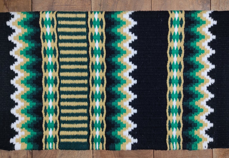 May include: A black, green, and gold woven saddle blanket with a geometric pattern.