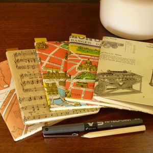 May include: A stack of six vintage paperbacks with colourful covers. The covers feature maps, musical notes, and a vintage illustration of a ladder on wheels. The text on the covers includes "Monotour Ranger", "Model No. 2.29 Ladder on Wheels", and "No. 2.24 Slitter".