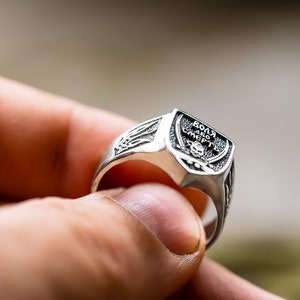 May include: A silver ring with a skull and crossbones design and the inscription "ВОЛЯ АБО СМЕРТЬ" (meaning "Freedom or Death").