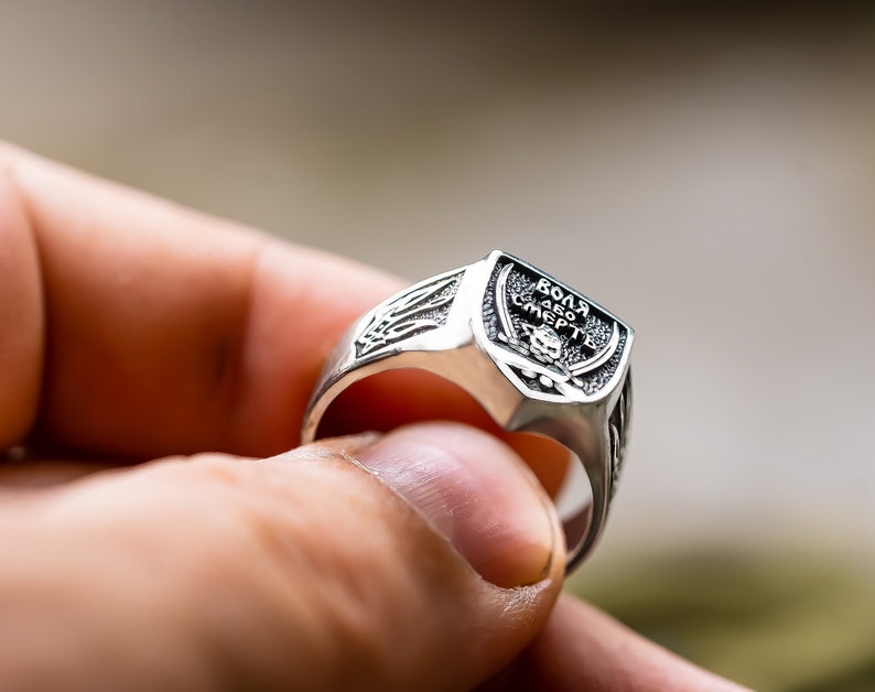 May include: A silver ring with a skull and crossbones design and the inscription "ВОЛЯ АБО СМЕРТЬ" (meaning "Freedom or Death").