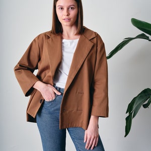 This oversized cotton jacket offers both comfort and freedom of movement. Crafted from 100% organic cotton with GOTS certification. Suitable for various occasions, this loose-fitting blazer complements both casual and formal looks.