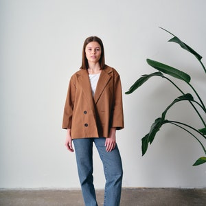 This oversized cotton jacket offers both comfort and freedom of movement. Crafted from 100% organic cotton with GOTS certification. Suitable for various occasions, this loose-fitting blazer complements both casual and formal looks.