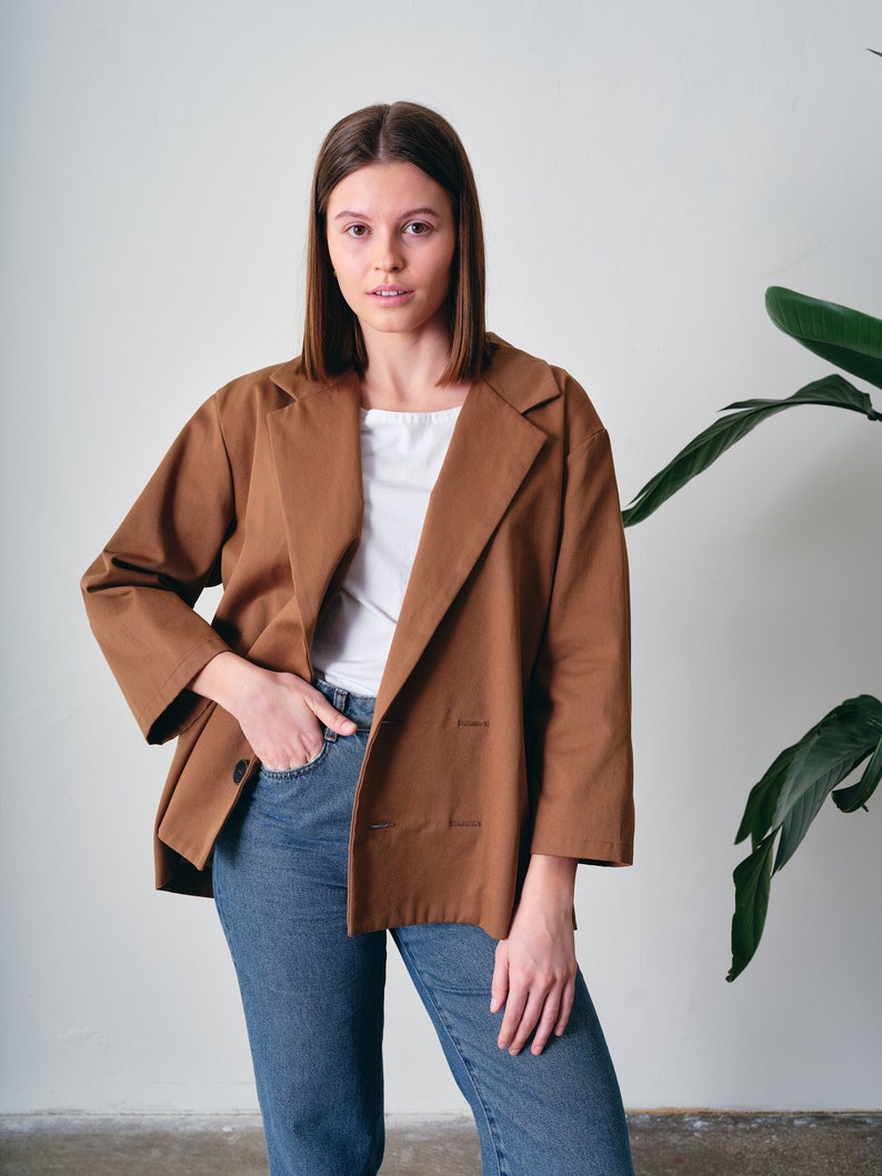 This oversized cotton jacket offers both comfort and freedom of movement. Crafted from 100% organic cotton with GOTS certification. Suitable for various occasions, this loose-fitting blazer complements both casual and formal looks.