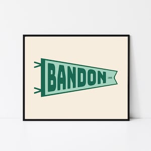May include: A green and white pennant with the word "BANDON" in bold, green letters and the year "1999" in smaller, white letters.