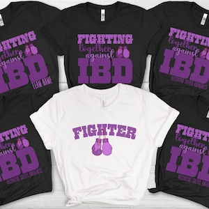 May include: Five black t-shirts with purple text and graphics. The text reads "Fighting together against IBD". One white t-shirt with purple text and graphics. The text reads "FIGHTER".
