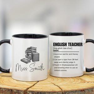 May include: White ceramic mug with a black handle and rim. One side features a stack of books and the name "Miss Smith". The other side has the text "ENGLISH TEACHER" with a definition and humorous attributes.