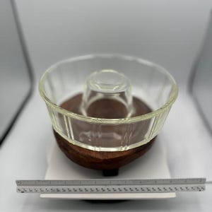 May include: A clear glass chip and dip serving bowl with a wooden base. The bowl has a central compartment for dip and a larger outer bowl for chips. A ruler is placed in front of the bowl. The bowl measures approximately 12 inches in diameter.