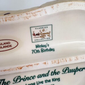 Op de afbeelding: Een wit keramisch verzamelobject met de tekst "Mickey's 70th Birthday" en "The Prince and the Pauper". Het heeft een "Walt Disney Collection" logo en is gemaakt in Thailand.