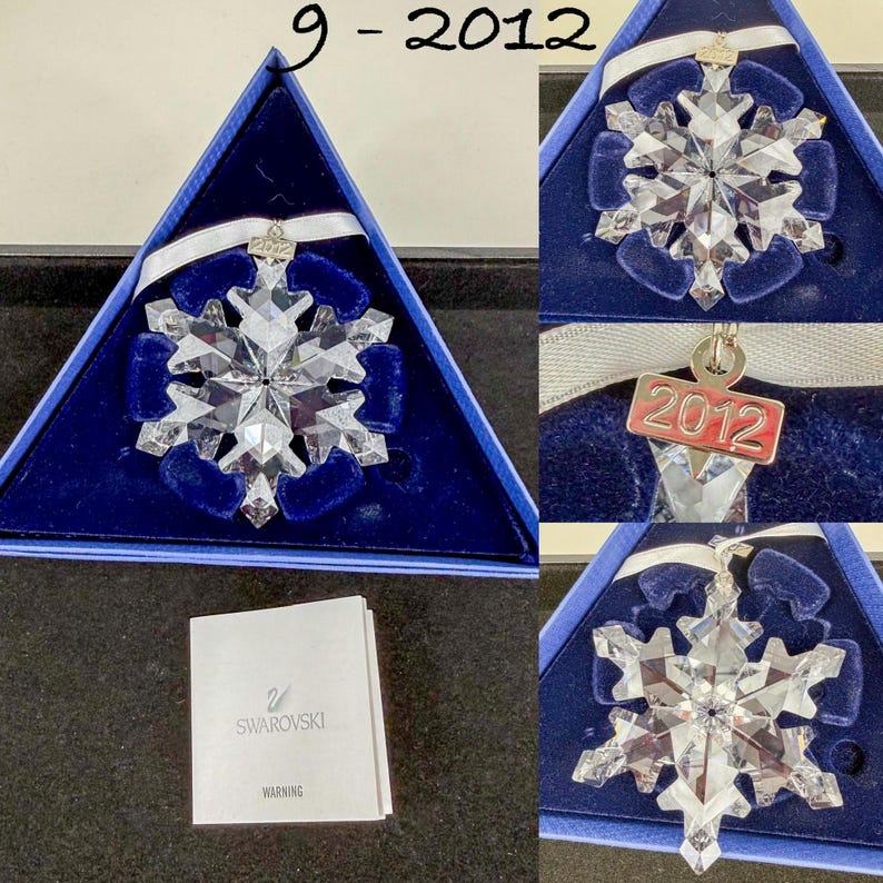 May include: A clear faceted crystal snowflake ornament with a white ribbon and a silver-toned metal tag engraved with the year 2012. The ornament is presented in a triangular blue box with a dark blue velvet insert and includes a Swarovski warning booklet.