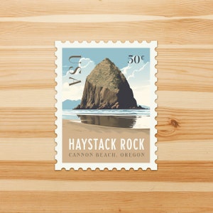 May include: A postage stamp featuring Haystack Rock in Cannon Beach, Oregon. The stamp has a light blue sky with clouds, a brown rock formation, and a sandy beach. The stamp reads "USA" and "50¢".