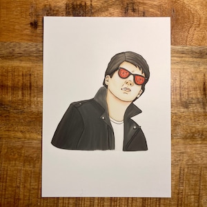 May include: A drawing of a person wearing a black leather jacket and sunglasses with the words "EAT UP!" written on them.