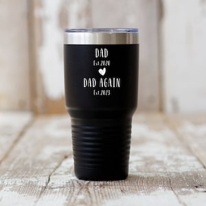 May include: Black stainless steel tumbler with white text that reads "Dad Est. 2020" with a heart symbol and "Dad Again Est. 2023".