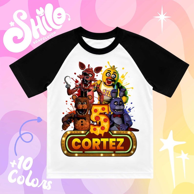 May include: A white t-shirt with black raglan sleeves featuring a graphic print of four animatronic characters, a large number five decorated with pepperoni pizza slices, and a glowing sign with the name CORTEZ in bold orange letters.