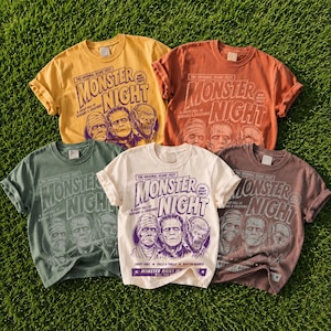May include: Four short-sleeve t-shirts in yellow, orange, green, and cream, each featuring a graphic print with the text "MONSTER NIGHT" and illustrations of a mummy, Frankenstein's monster, and a werewolf, styled like a vintage horror movie poster.